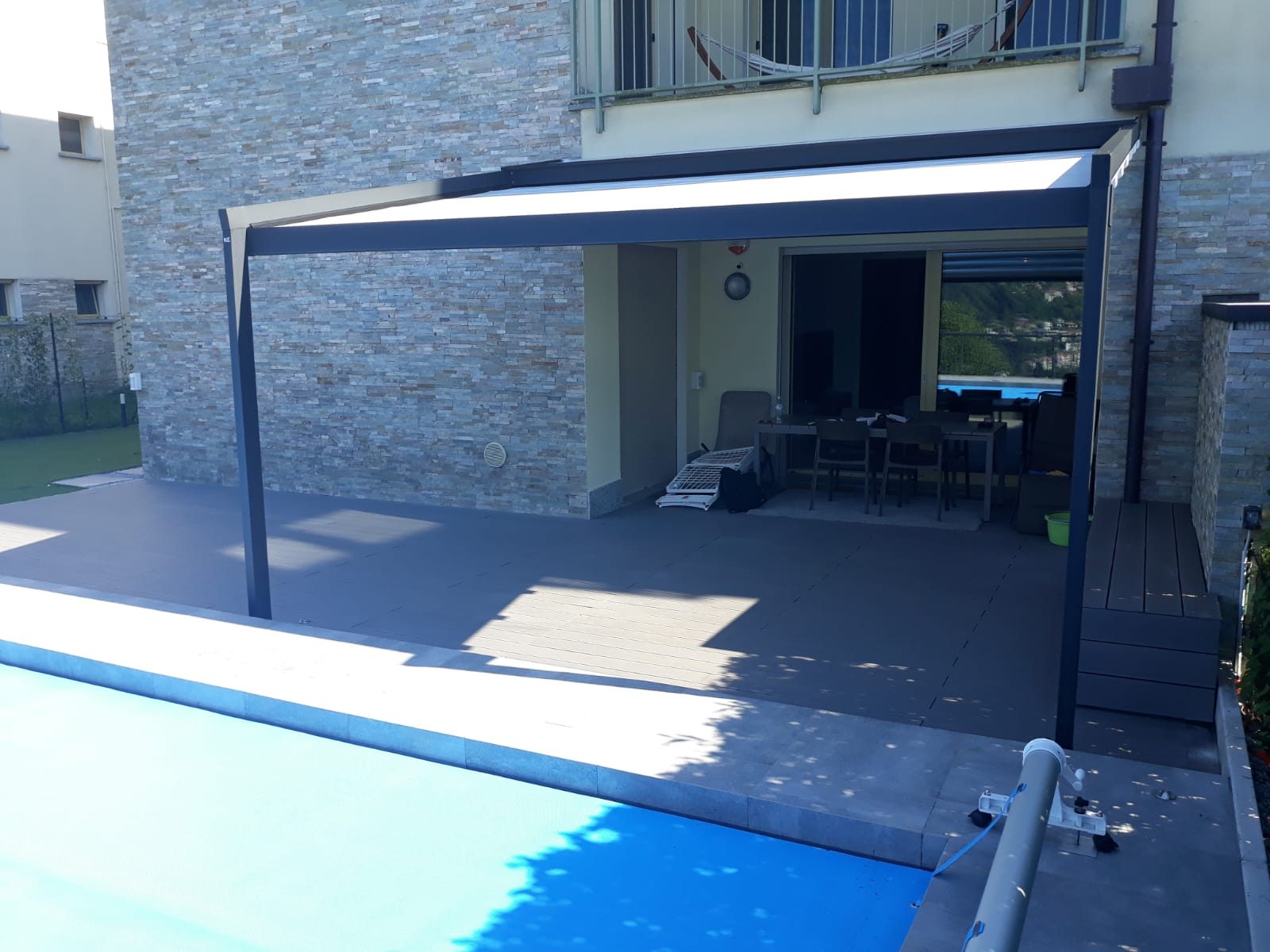 Pergola con telo avvolgibile motorizzato installata a bordo piscina